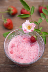 Strawberry milk and rose on wood table