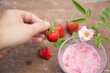 Strawberry milk and rose on wood table