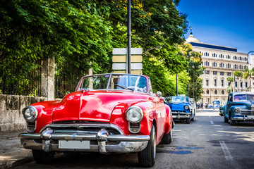 HDR - Roter amerikanischer Oldsmobile Oldtimer parkt auf dem Malecon in Havanna Stadt Kuba - Serie Cuba Reportage - obrazy, fototapety, plakaty