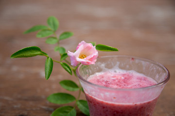 Strawberry milk and rose on wood table