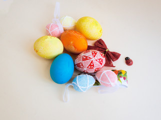 Fototapeta na wymiar Easter eggs, bow, ladybug on a light paper background.