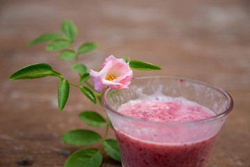 Strawberry milk and rose on wood table