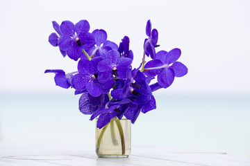 Close up beautiful bouquet of orchids flower on wooden table near sea. Thailand