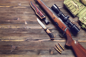 Hunting equipment on old wooden background.