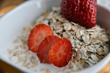 Breakfast: granola with berries fresh strawberries on wooden background natural rustic. The concept of healthy eating.