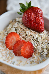 Breakfast: granola with berries fresh strawberries on wooden background natural rustic. The concept of healthy eating.