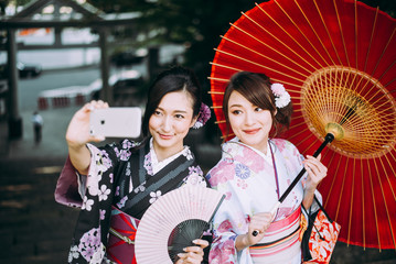 Two japanese girls wearing kimonos traditional clothes, lifestyle moments
