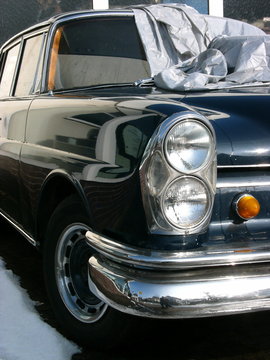 Doppelscheinwerfer der US Version einer schwarzen deutschen Limousine der Sechzigerjahre bei Sonnenschein in Wettenberg Krofdorf-Gleiberg bei Gie&szlig;en in Hessen