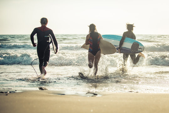Three surfers practicing in the ocean