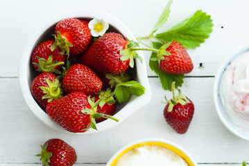 strawberry fruits with jam and whipped cream dessert on white wood table background