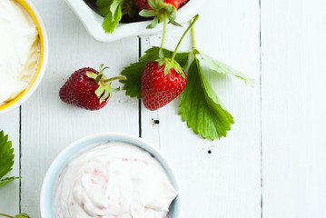 strawberry fruits with jam and whipped cream dessert on white wood table background