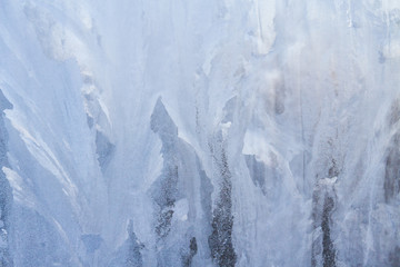 Winter frosty patterns on the frozen ice window