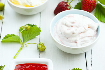 strawberry fruits with jam and whipped cream dessert on white wood table background