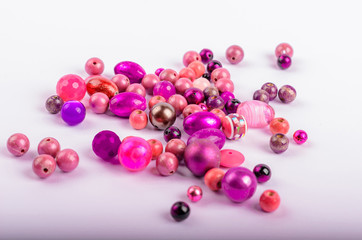 on the rigt on a white background neatly laid out purple and purple beads on the left there is space under the text