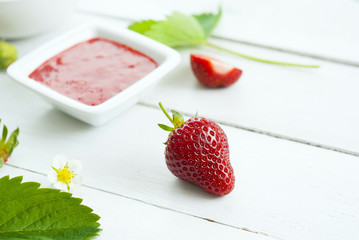strawberry fruits with jam and whipped cream dessert on white wood table background