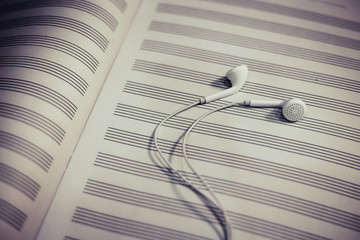 Headphones on the blank music notes paper