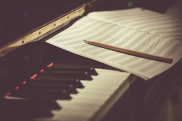 Compose Concept. Pencil and sheet music on the piano keyboard