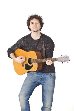 Young man wearing in black shirt and jeans playing on a gitare