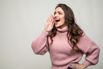 Young beauty woman shout and scream using her hands as tube, studio shoot isolated on white background