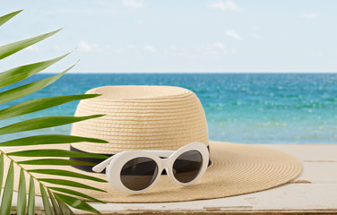 Summer seascape. Relax on the beach, hat and white sunglasses.