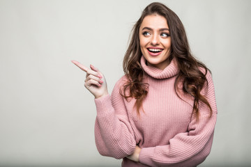 Smiling woman pointing finger side isolated portrait on white background.