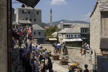 People crossing the famous Stari Most bridge in Mostar in summer season