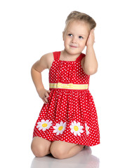 Little girl is sitting on the floor.