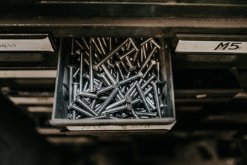 a film cenamatic style looking of nails organized by a big metal drawers