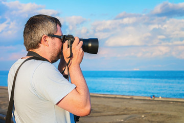 Fototapeta na wymiar Man with camera Mediterranean sea at Santa Teresa di Riva