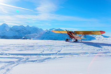 Yellow airplane at Mountain peaks in Mannlichen