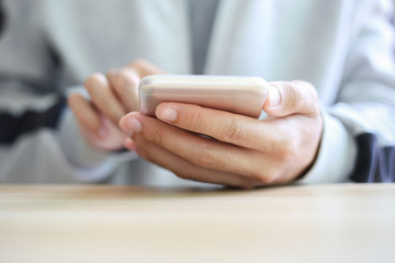 Man playing smartphone on the table