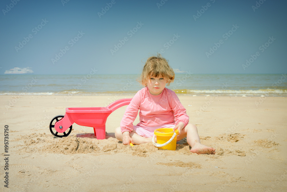 Poster belle enfant et ses jouets sur la plage