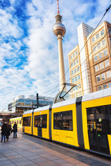 Running tram on Alexanderplatz with television tower in Berlin