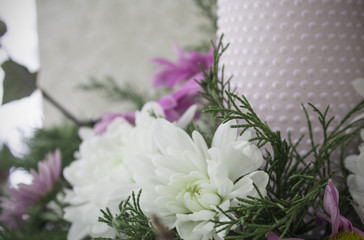 White and pink chrysanthemums with ivy and juniper branches. Festive flower arrangement. Chrysanthemums and candle