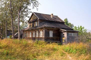 Fototapeta na wymiar Big old wooden house in russian village in summer day