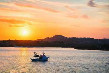 Sunrise with ship at Costa Smeralda at Mediterranean sea Sardinia