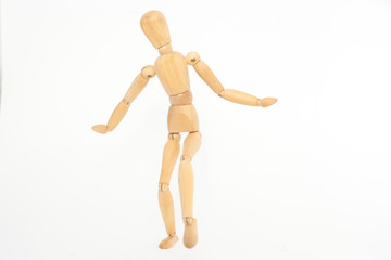 The wooden mannequin steps uncertainly. On a white background.