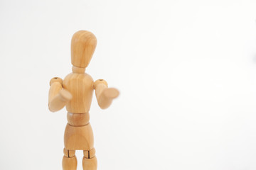 A wooden dummy offers something. On a white background.