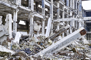 Remains of the destroyed industrial building. The skeleton of a large building of concrete beams