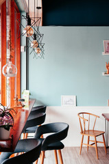 Cafe interior decoration with modern furniture, lamps and pastel wall color 