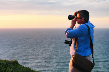 Man taking photos of sunset in Portoscuso Carbonia Sardinia