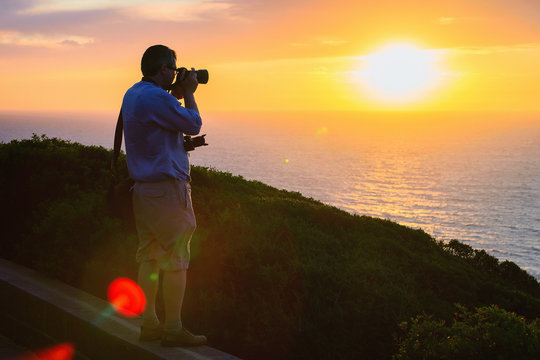 Man taking photos of sunset at Portoscuso Carbonia Sardinia
