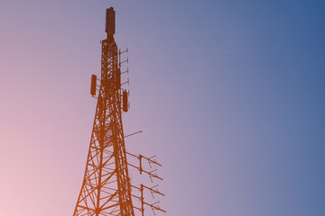 Beautiful silhouette of base station tower with twilight background during sunset