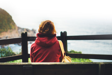 Hipster hiker tourist looking on seascape sunset, background blue sea and mountain, girl enjoying ocean horizon, panoramic sunrise, traveler relax holiday concept, sunlight view in trip vacation