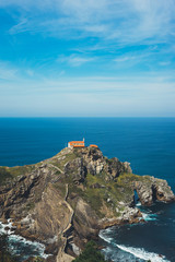 Fototapeta na wymiar Sea scape on background gaztelugatxe steps sun huan, nature horizon ocean, relax holiday, blank space blue waves view, travel trip on Basque country in Spain, popular place of movies
