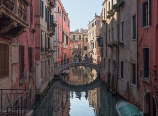 Fototapeta na wymiar small canal of Venice with ancient buildings with peeling walls that preserve their charm. Italy