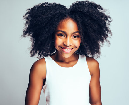 Cute Young African girl smiling confidently against a gray backg