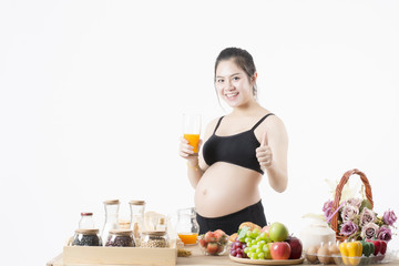 Obraz na płótnie Canvas Pregnant women drinking orange juice in the kitchen