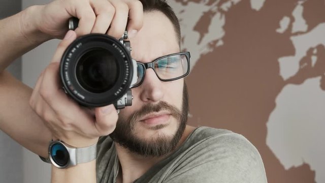 Photographer man working in a photo studio. Close up portrait handsome man taking pictures with professional camera