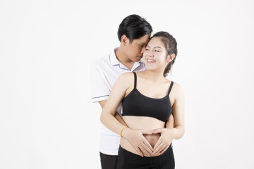 Naklejka premium Beautiful pregnant woman and her handsome husband hugged her belly.